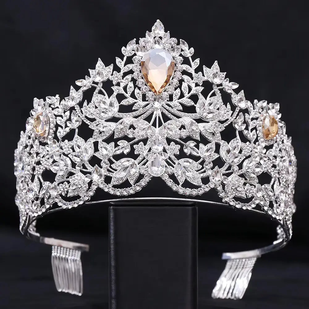 Ornate silver tiara adorned with intricate floral designs and sparkling gemstones.