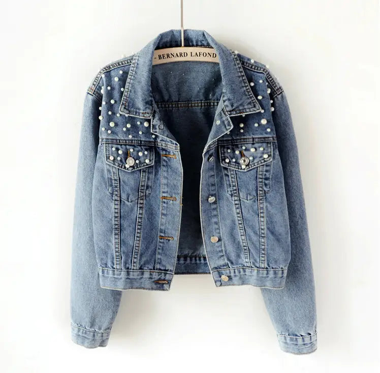 Denim jacket embellished with pearl-like studs on the collar and chest pockets.