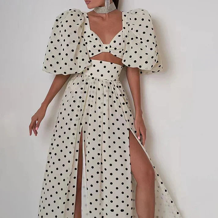 Polka dot dress with puffed sleeves and a high slit.