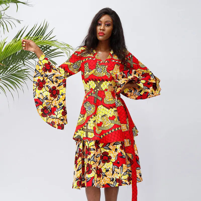 Colorful African-inspired dress with vibrant patterns and flared sleeves.