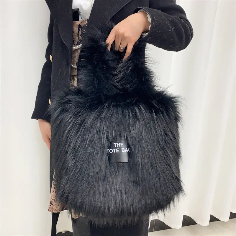 Black furry tote bag with THE TOTE BAG label, perfect for a large capacity crossbody tote bag.