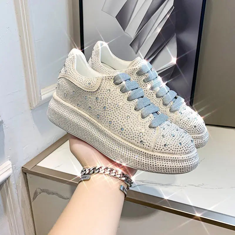 Stylish white sneaker with rhinestone bling and light blue laces, perfect leisure shoes.