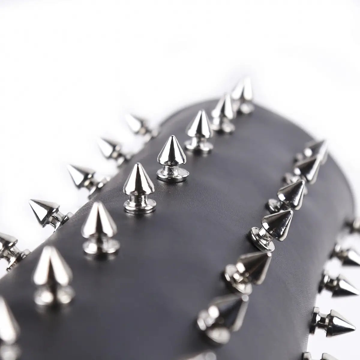 Metal spikes on a dark surface for Spiked Leather Arm Guard in erotic bondage play.