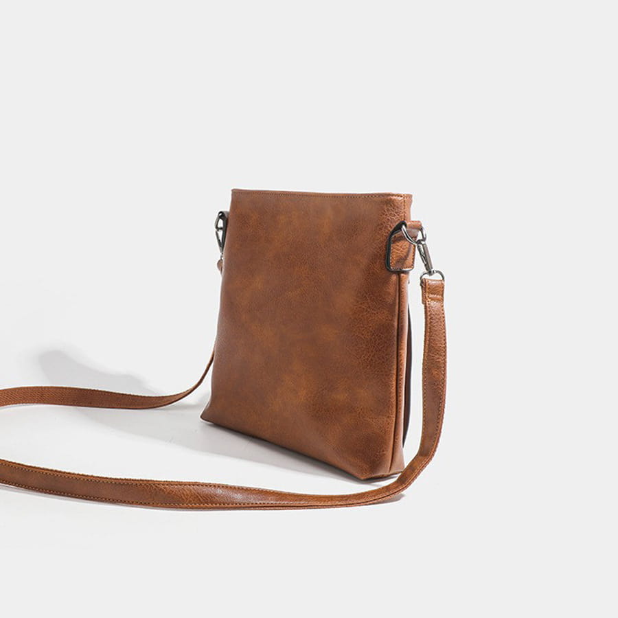 Brown leather crossbody bag with a long strap in high-end textured artificial leather.