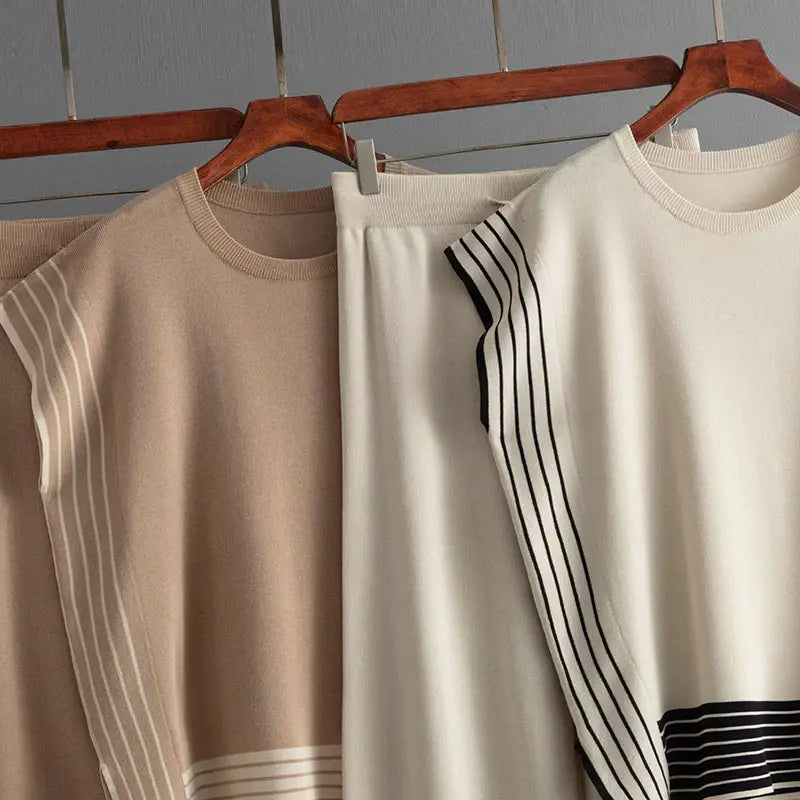 Three neutral-toned sweaters on hangers perfect for high waist wide leg pants styles.