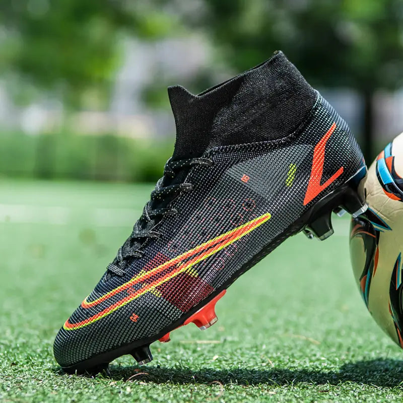 Crampon de football Nike noir avec swoosh orange et jaune pour les chaussures de football sur gazon.