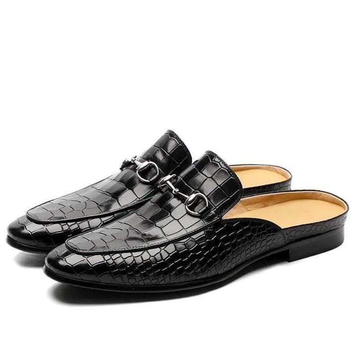 Black crocodile-textured leather backless moccasin loafers with metal horsebit detail.