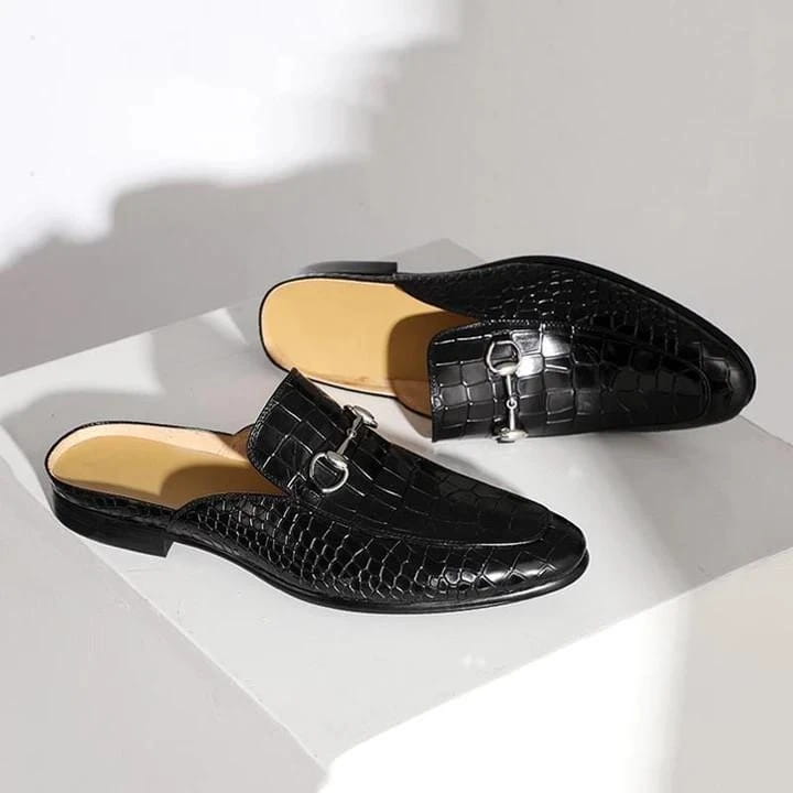 Black crocodile-textured leather backless moccasin loafers with metal horsebit detail.