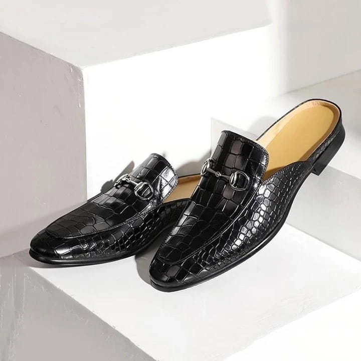 Black crocodile-textured leather backless moccasin loafers with metal horsebit hardware.