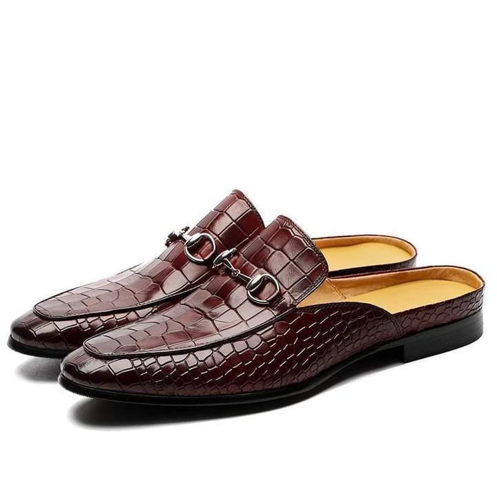 Brown crocodile-textured leather backless moccasin loafers with metal horsebit hardware.