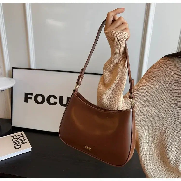 Brown leather shoulder bag with curved silhouette, perfect crossbody bag luxury for ladies.