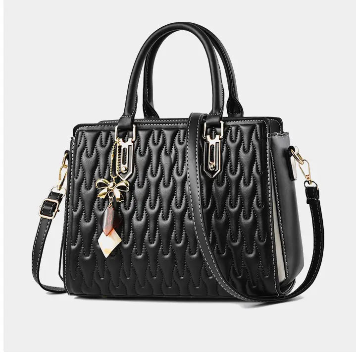 Black quilted handbag with gold hardware, perfect for a high capacity fashion handbag style.