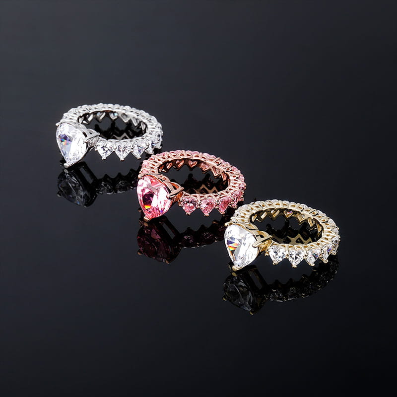 Three ornate heart-shaped gemstone rings in silver, rose gold, and gold settings.