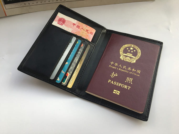 Black leather passport holder with a Chinese passport, perfect for travel essentials.