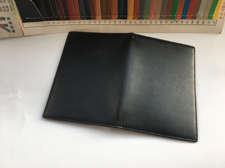 Stylish Black Leather Travel Wallet with RFID protection and card slots open flat.