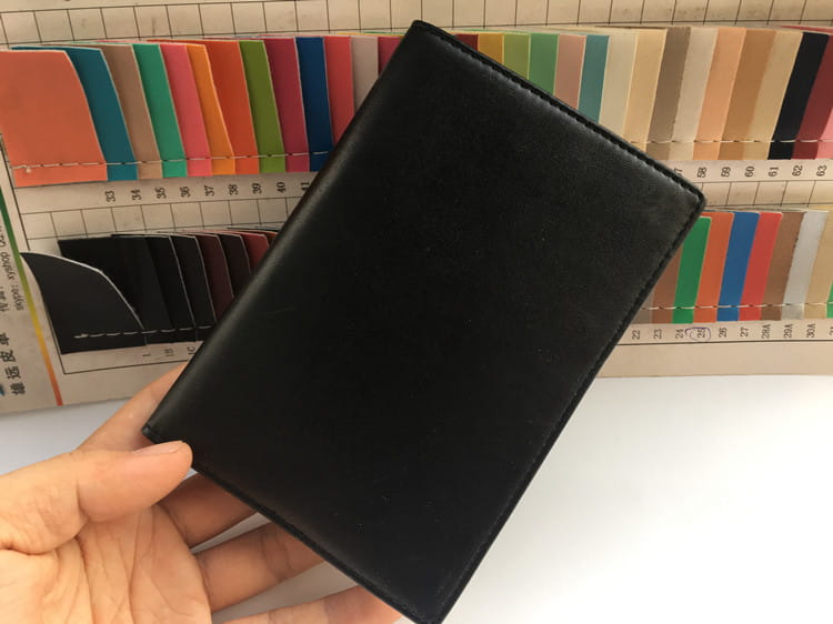 Stylish Black Leather Travel Wallet with RFID Protection and Card Slots in hand.