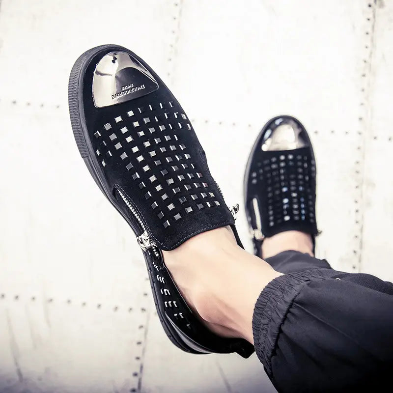 Black perforated slip-on shoes with metallic accents for bold British style rhinestone fashion.