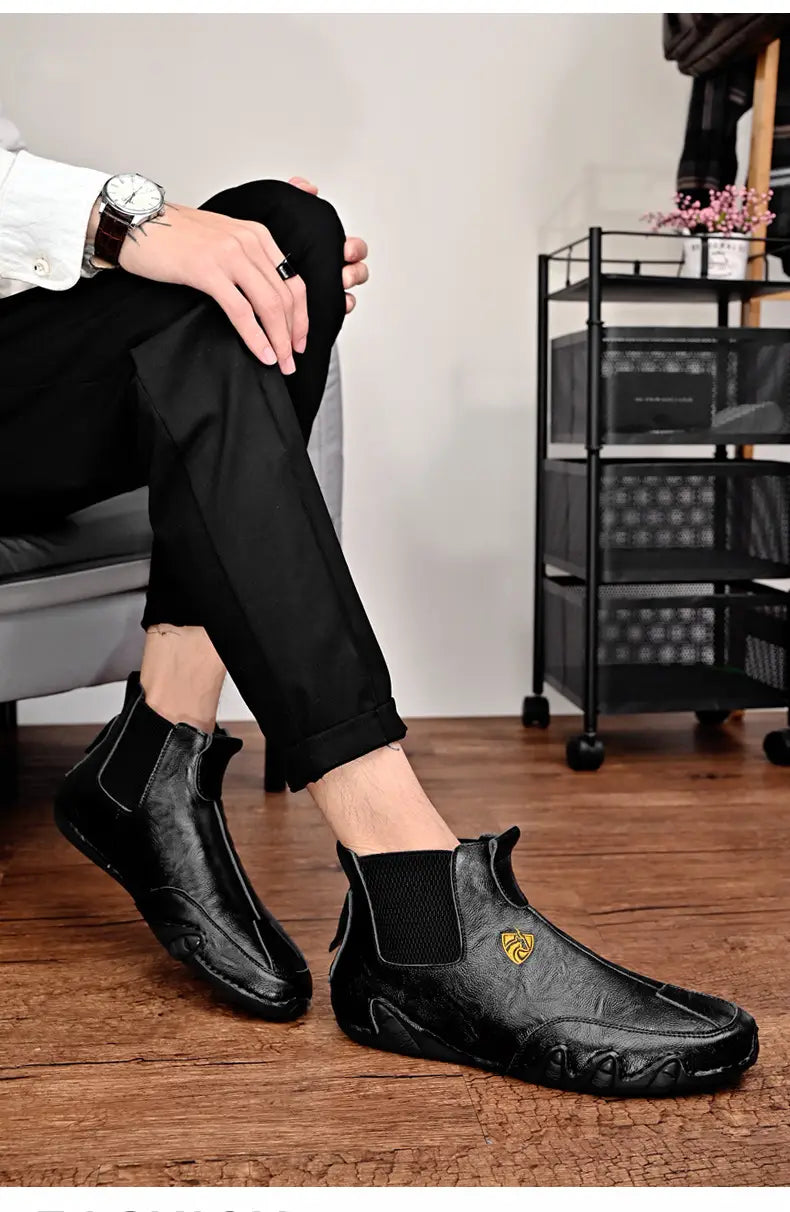 Black leather Chelsea boots with texture and yellow logo for warm men’s casual shoes.