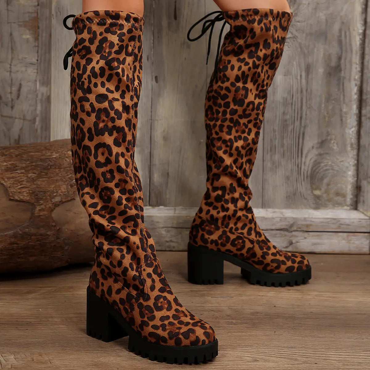 Leopard print knee boots with chunky heels and platform soles for a stylish look.