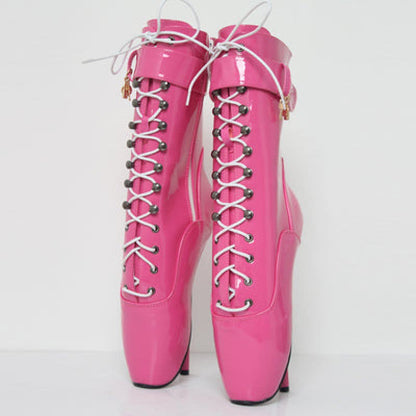 Pair of bright pink ballet-style boots with extreme high heels and lace-up fronts.