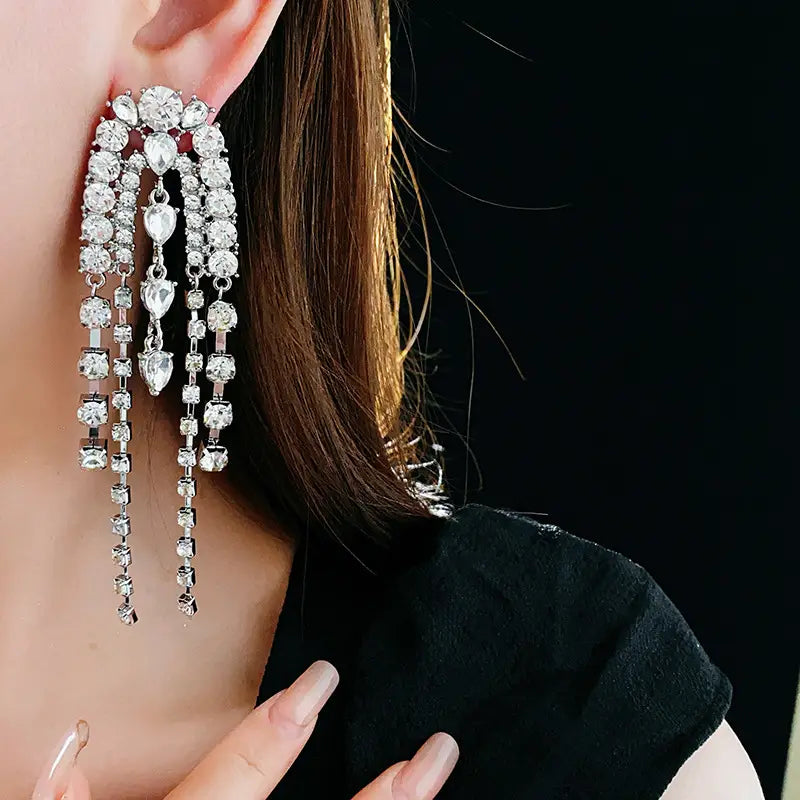 Sparkling water droplet shaped luxury tassel earrings with rhinestone strands.