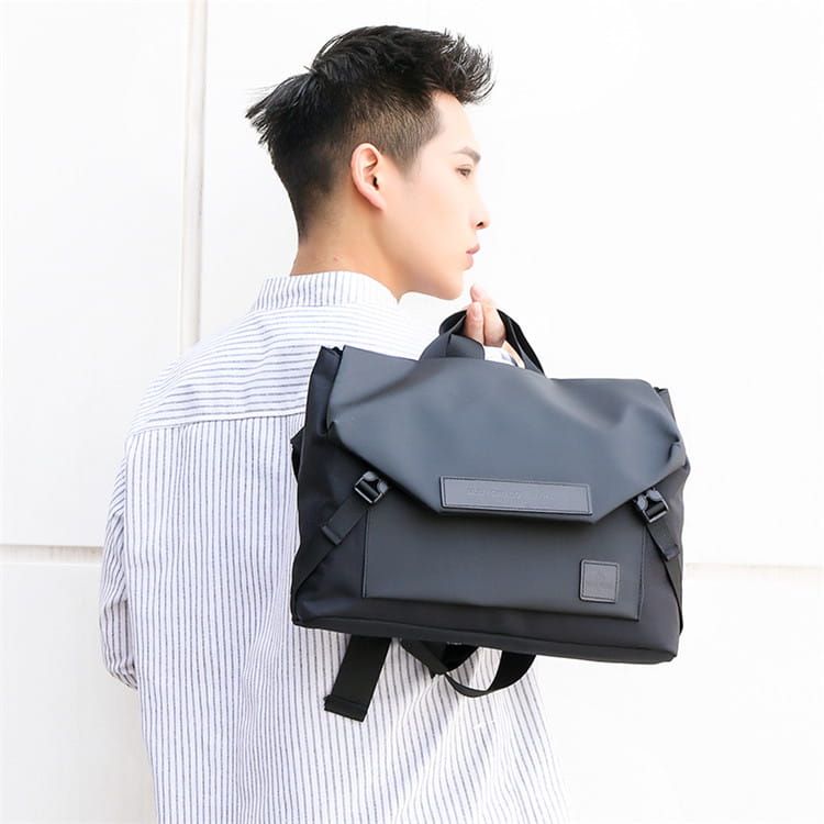 Sac bandoulière noir de style messager pour homme avec fermetures à boucle pour un style de grande capacité.