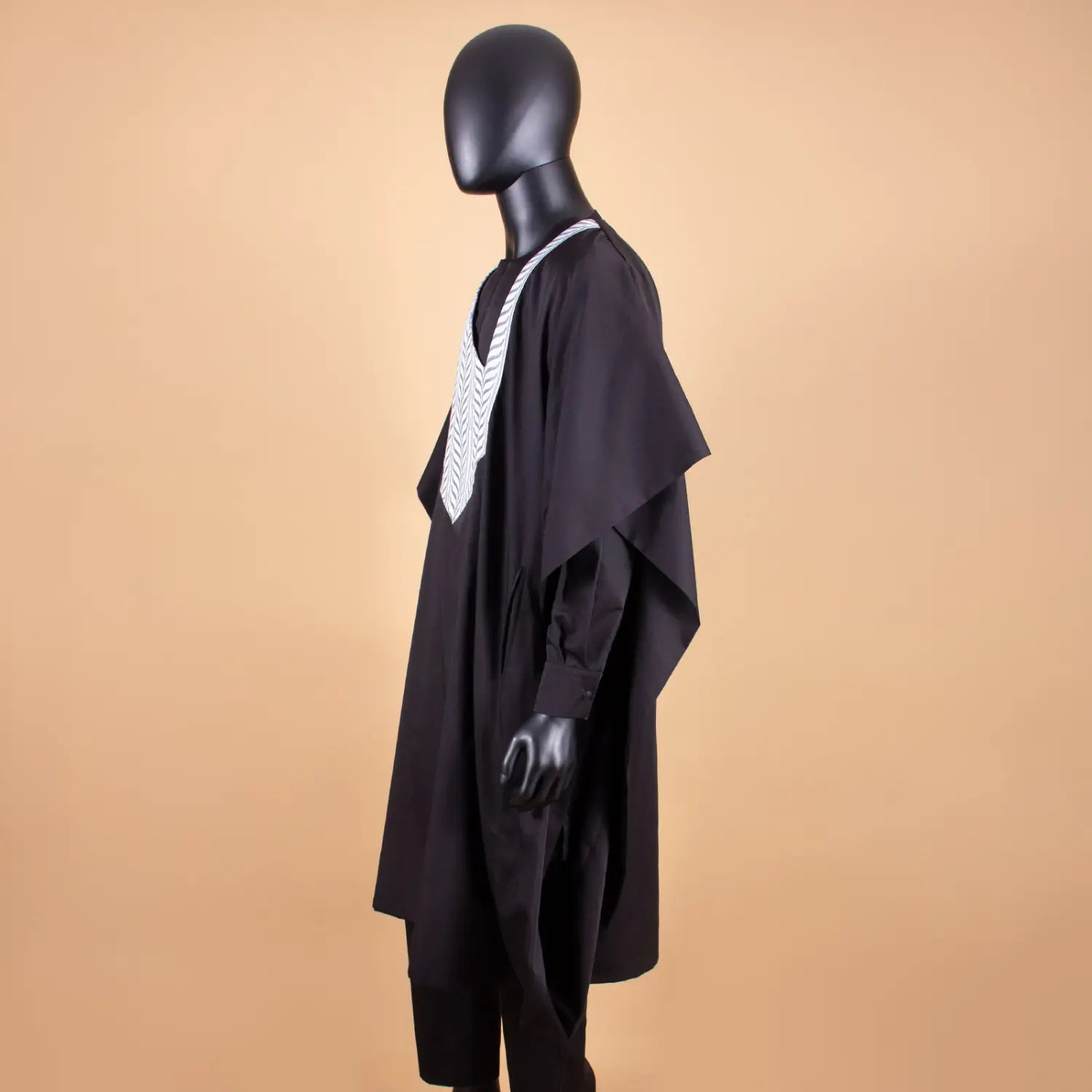 Black poncho-style garment with white detailing for Traditional African Men’s Tuxedo.