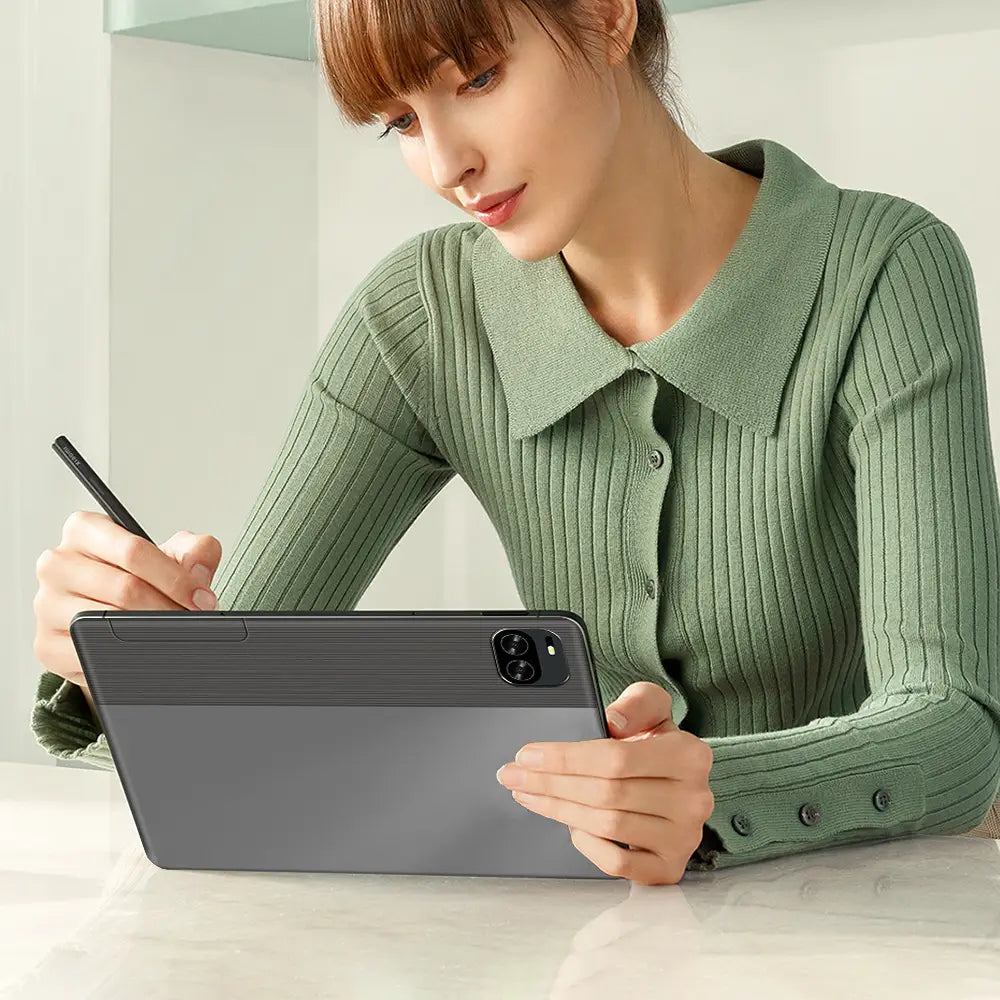 Person using a 10.1 inch screen Android tablet with stylus, wearing a green sweater.