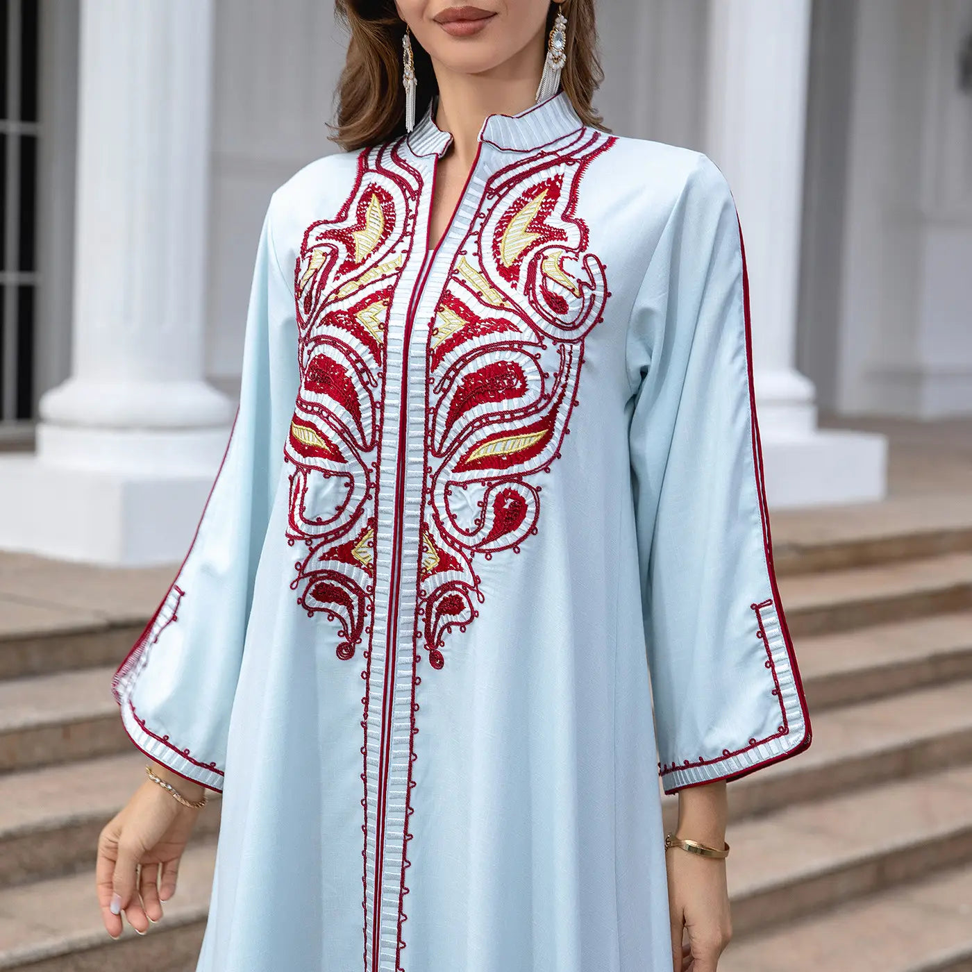 Light blue Ornate Muslim Middle East Embroidery Kaftan-style Dress with red patterns.