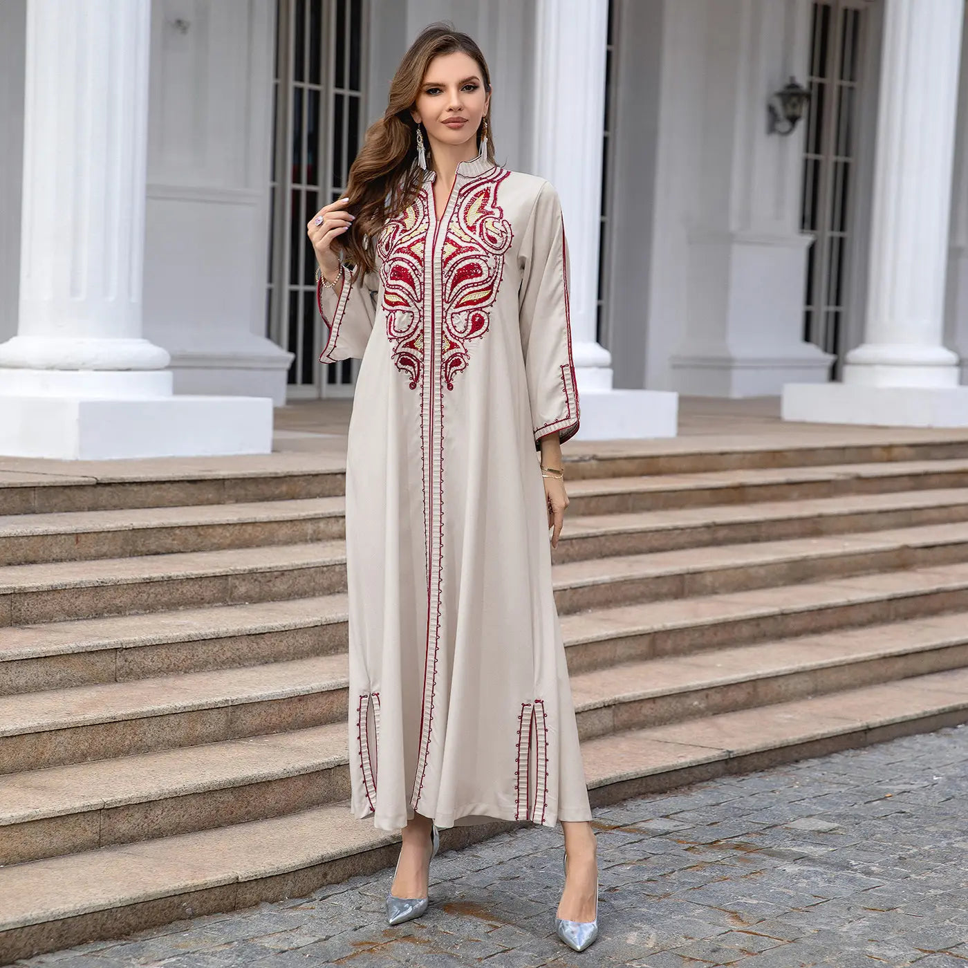 Beige Kaftan dress with red details showcasing Middle East embroidery style.