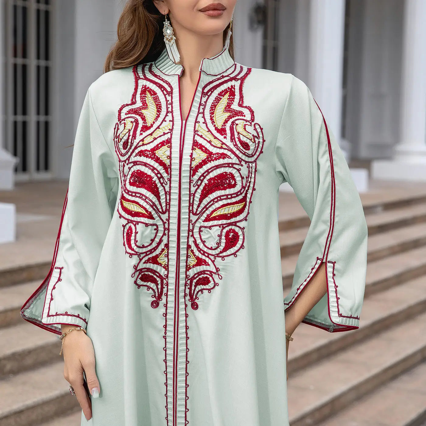 Mint green Ornate Muslim Middle East dress with vibrant red and gold embroidery.