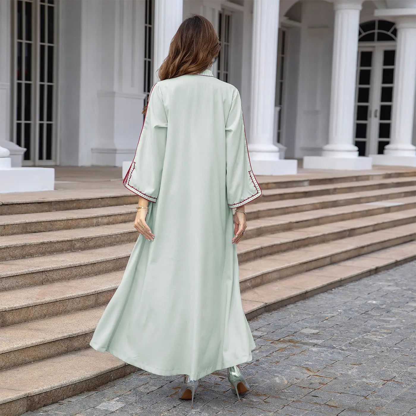 Mint green flowing maxi dress with Middle East embroidery and three-quarter sleeves.