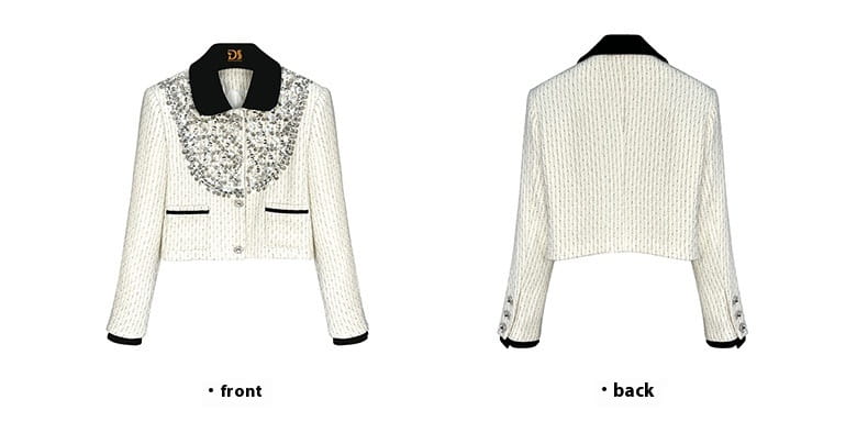 White cropped jacket with black trim and silver sequined collar, a chic Chanel style.