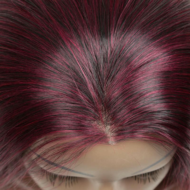 Close-up view of vibrant pink and burgundy hair with visible roots and eyelashes.