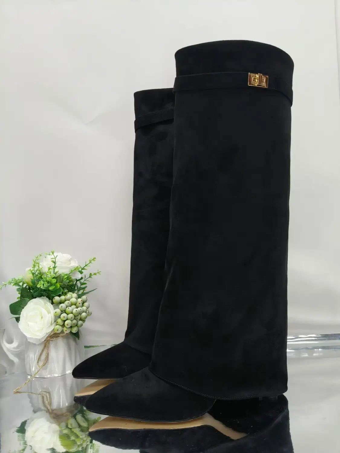 Grandes bottes en daim noir pour femmes, style Gucci, à bout pointu et à boucle métallique au niveau du genou, avec des détails dorés.