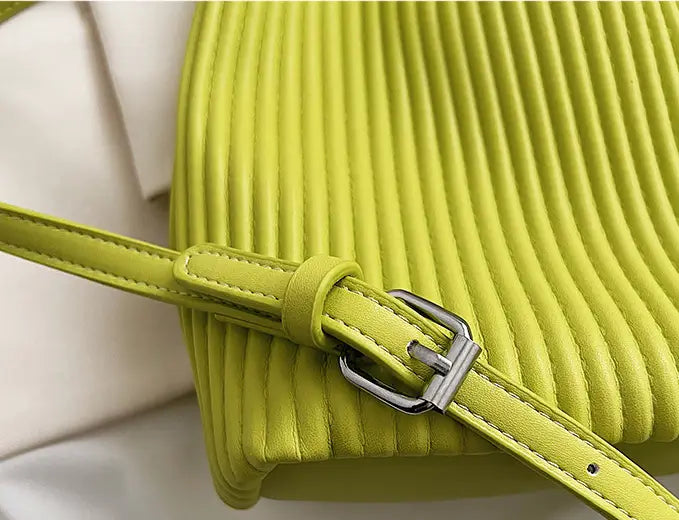 Lime green textured messenger bag with pleats and adjustable strap for women’s niche fashionable style.