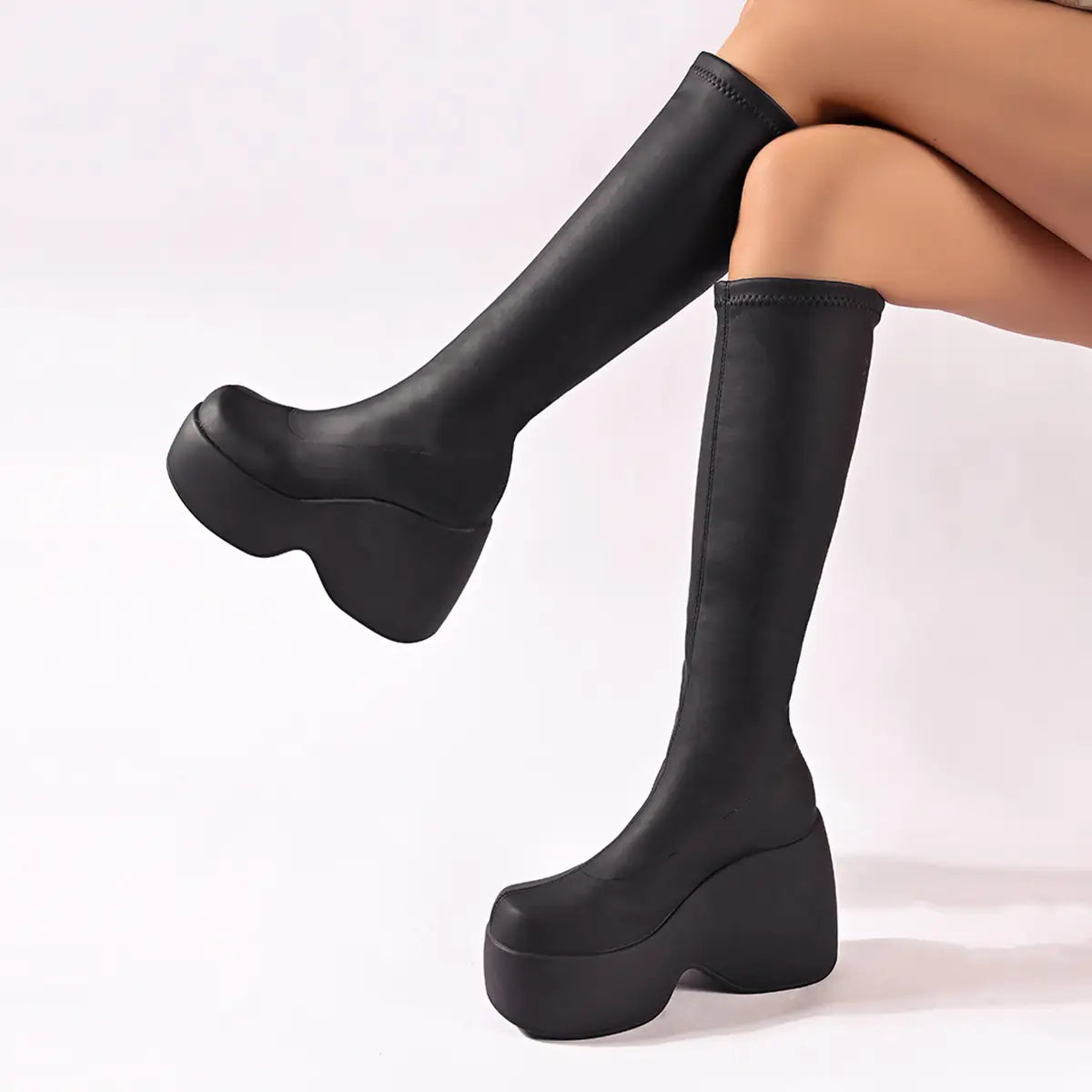 Black high chunky platform elasticated knee-length boots with chunky soles.