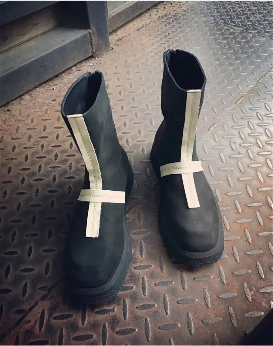 Black cross stitched leather statement piece boots with white crosses for a bold look.