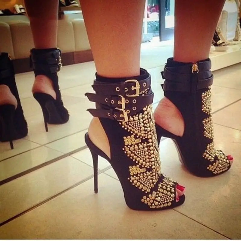 Black leather slingback fish mouth high-heel boots with gold studs and stiletto heels.