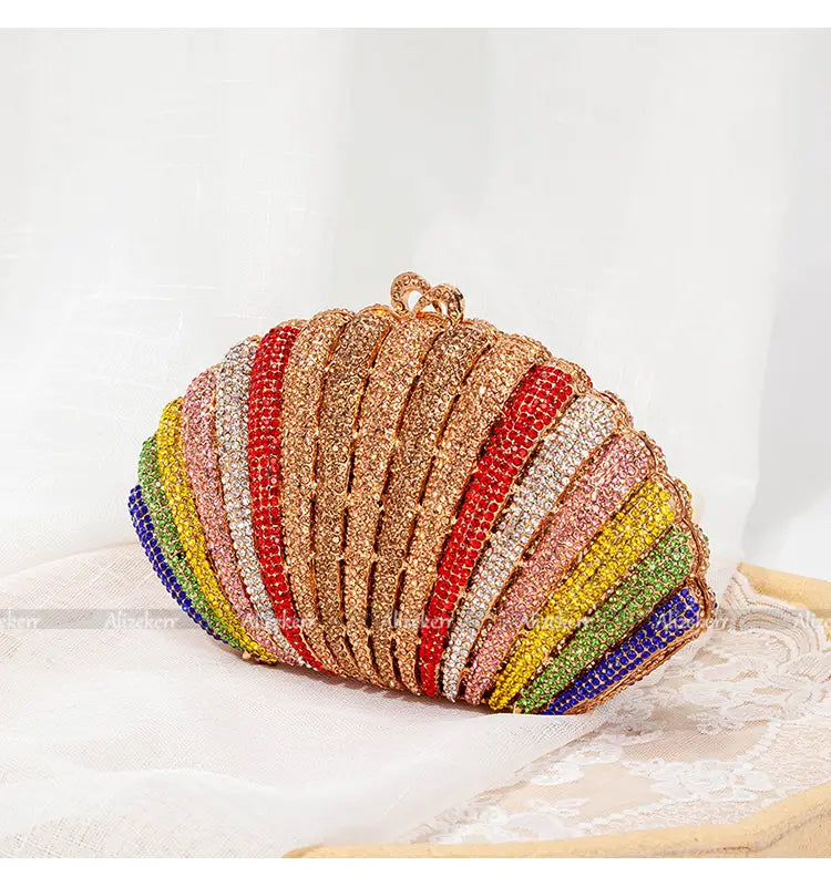 Seashell-shaped clutch purse with colorful beaded stripes and rainbow shell rhinestone design.