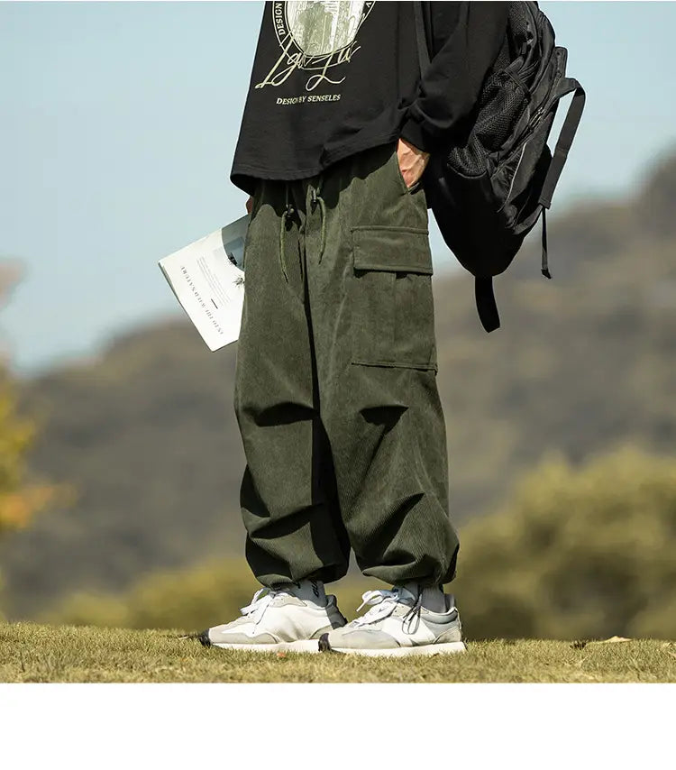 Olive green corduroy cargo pants with pockets and white sneakers for a casual look.