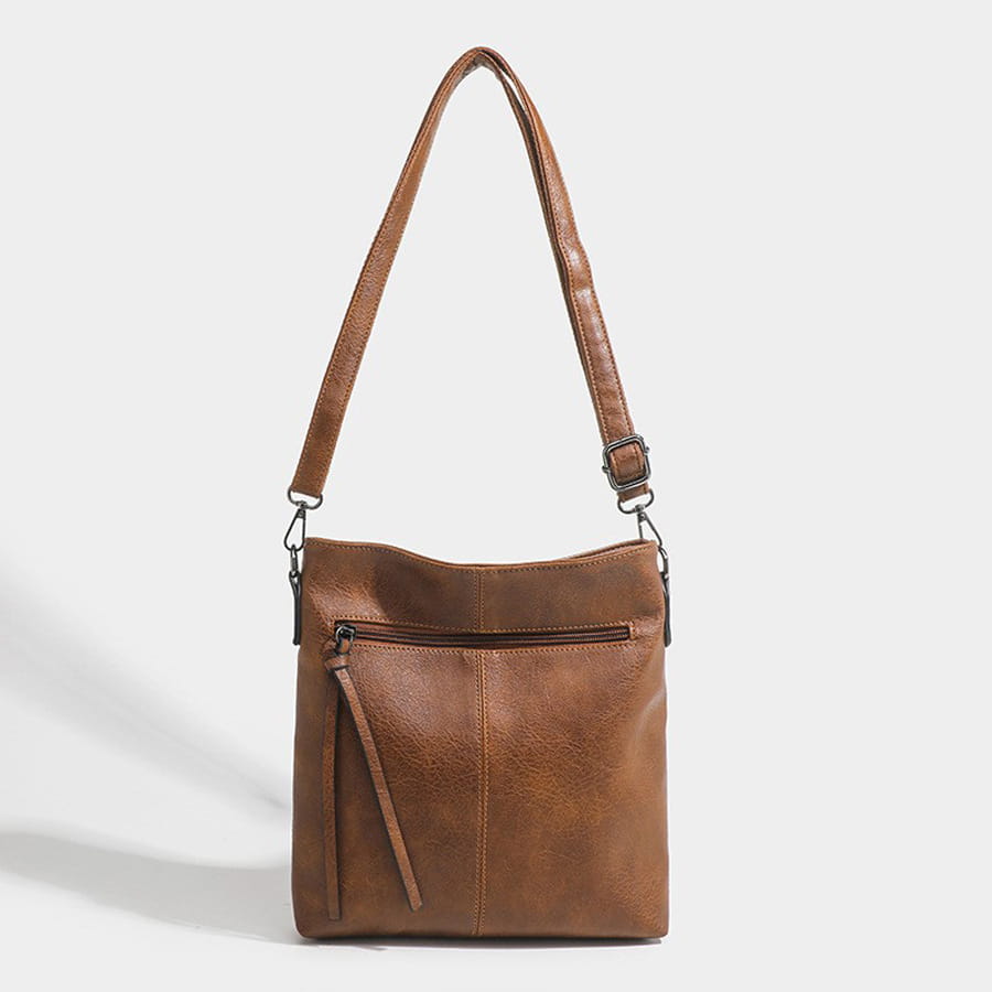 Brown leather crossbody bag with zipper, adjustable strap, and high-end textured artificial leather.