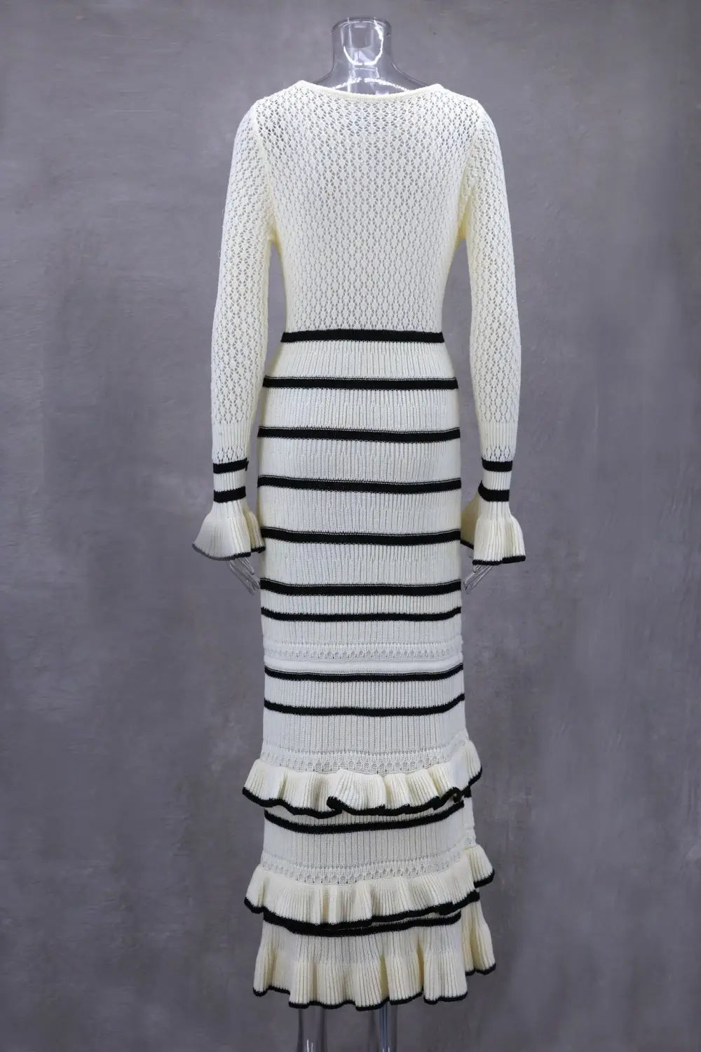 Elegant Ladies Knitted Dress in white and black with ruffled hem and slim fit style.