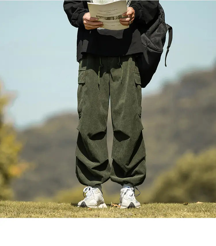 Olive green corduroy cargo pants paired with white sneakers for a stylish look.