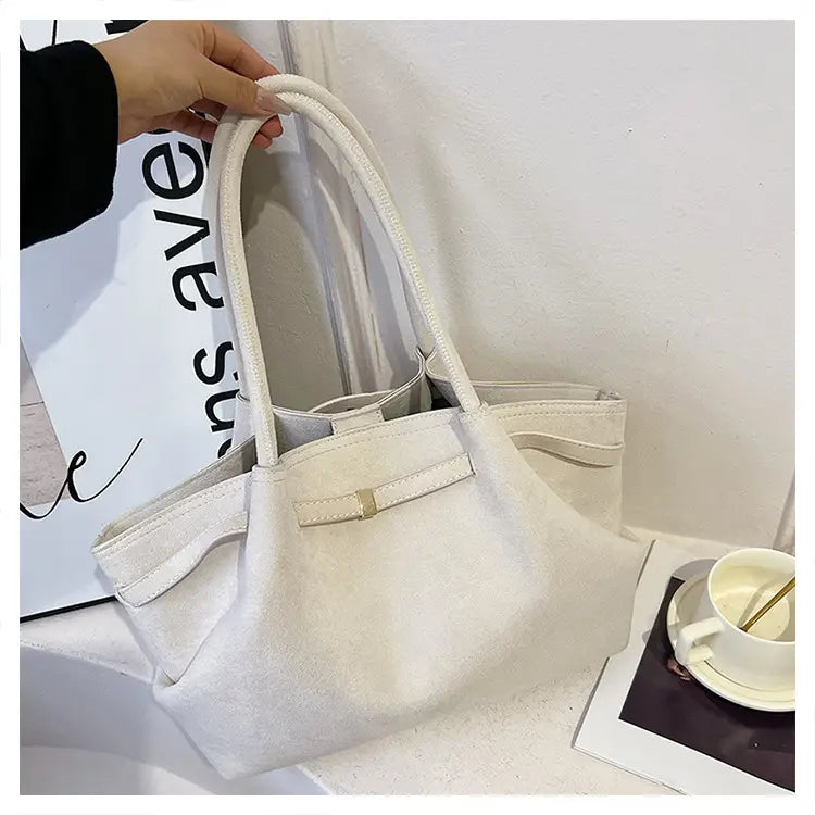 Sac à main en cuir blanc avec double poignée et détail de ceinture pour un fourre-tout élégant en daim.