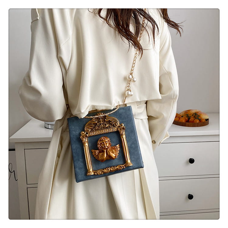 Stylish blue shoulder chain bag with ornate gold-framed cherub design.