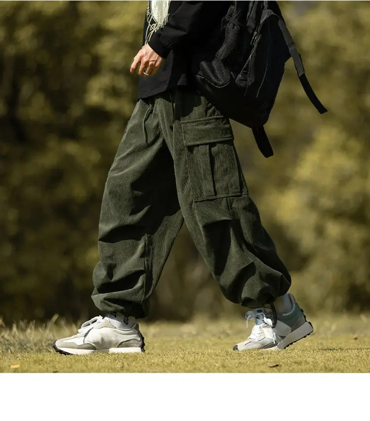 Olive green corduroy cargo pants with pockets paired with fresh white sneakers.