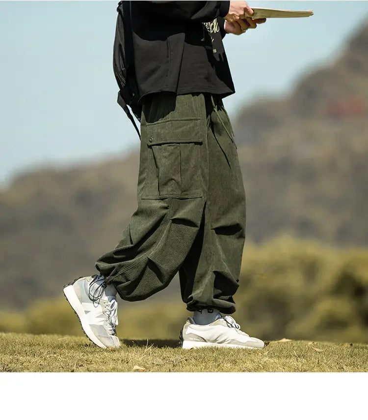 Olive green corduroy cargo pants with pockets and a comfy, baggy fit for men.