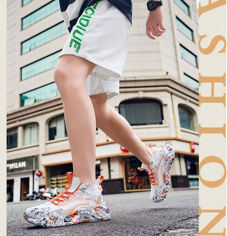 Chunky sneakers with graffiti print and orange accents, perfect shock-absorbing running shoes.