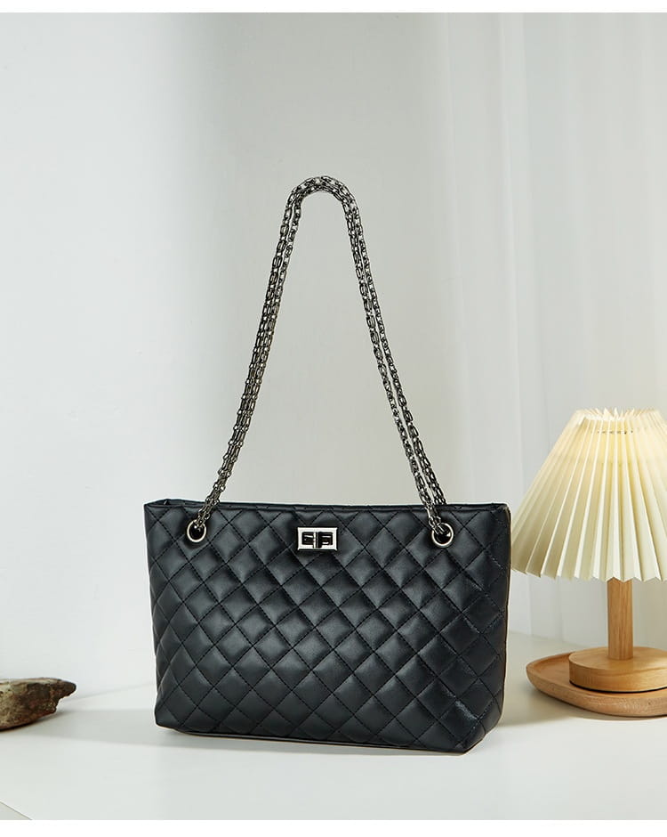 Black quilted leather handbag with shimmering chain strap and diamond plaid design.